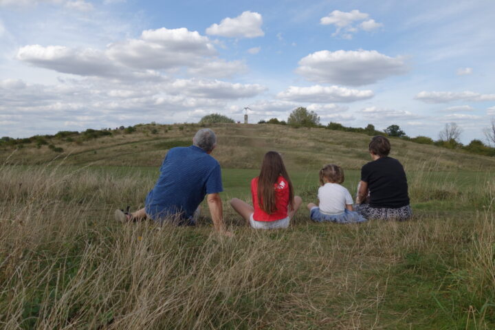 Family sitting on a grassy hill