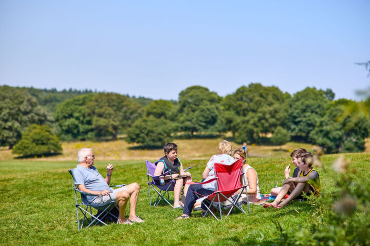 Family enjoying a picnic on chairs at Weald