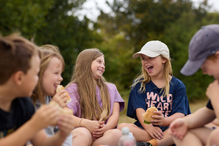 Kids eating and laughing in a park