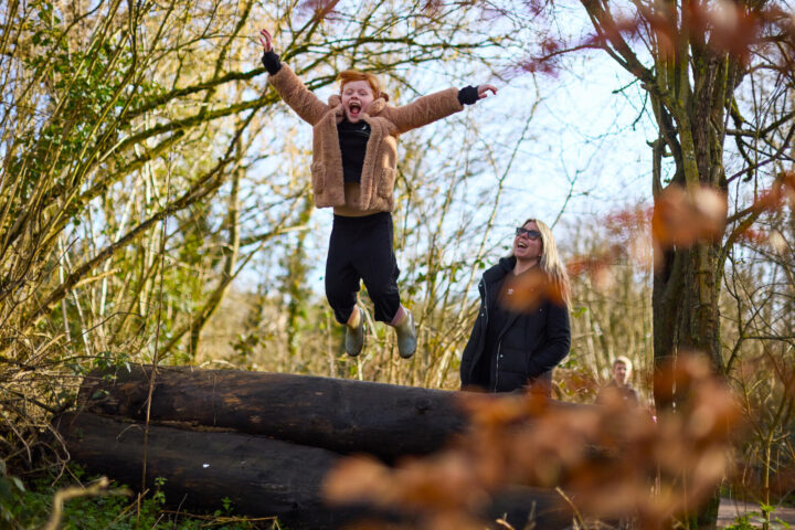 Young girl jumping in the air in the woodland