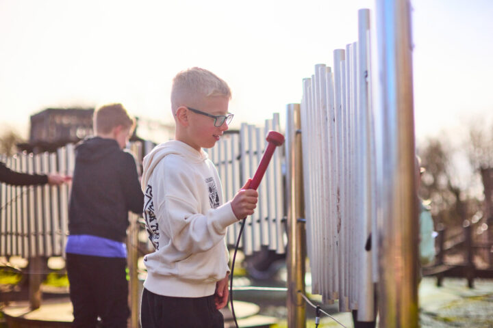 Boys using outdoor musical play equipment