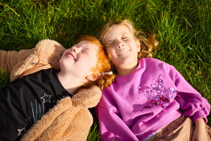 Two girls laying in the grass