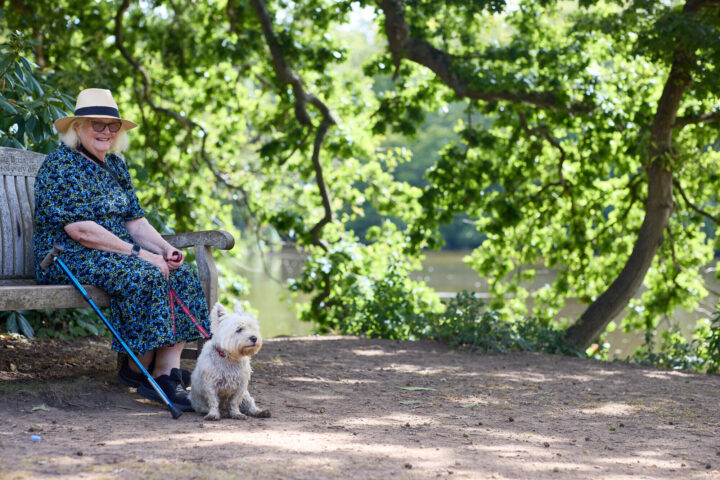 Older lady and her dog on bench by a lake