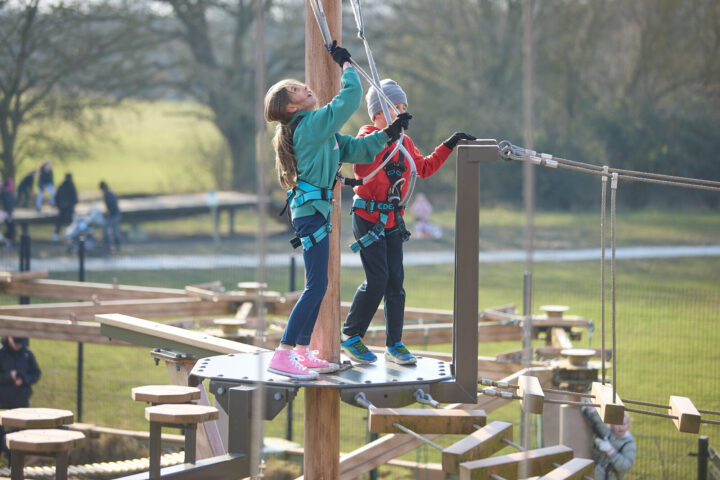 Girl on high ropes against a blue sky