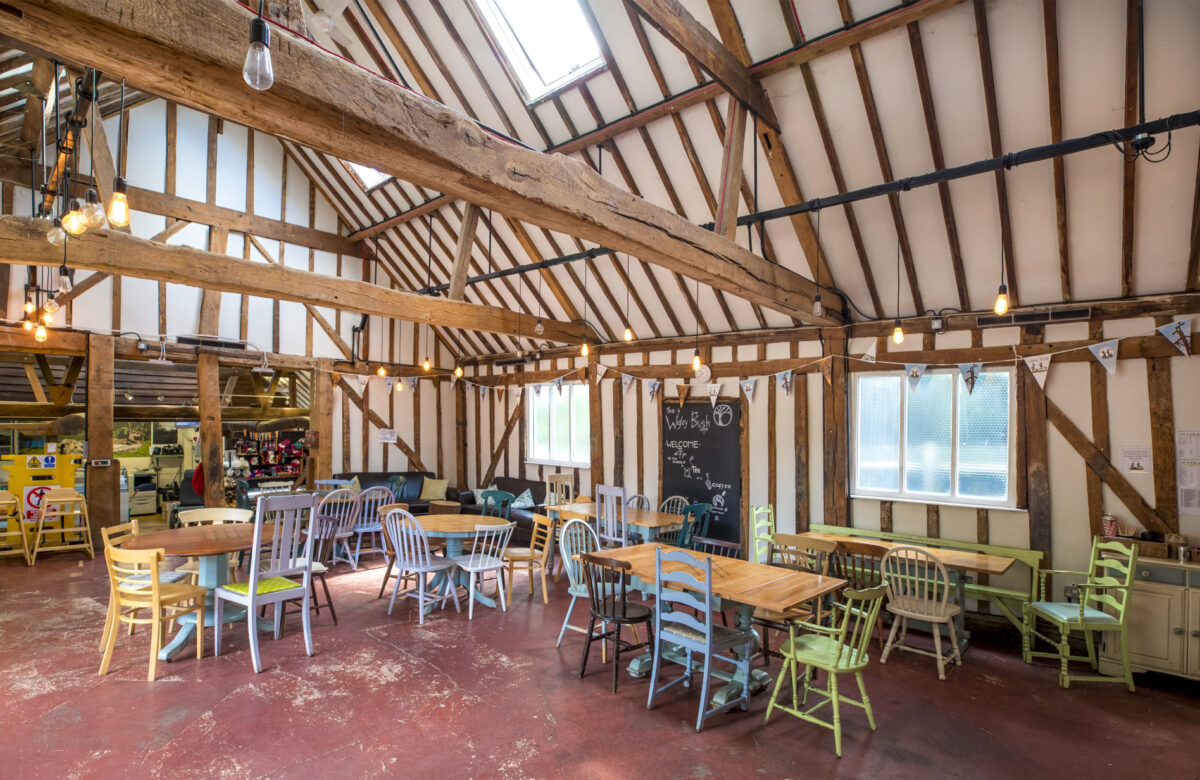 A beamed cafe with seating and tables