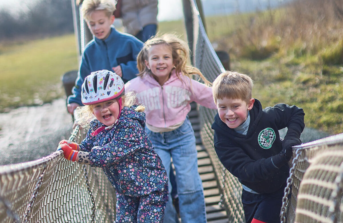 Group of kids on a play trail bridge