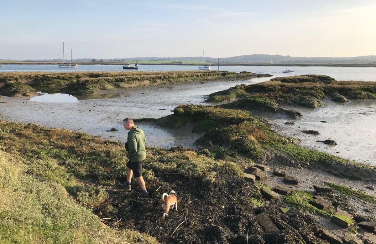 Man and dog at low tide on river Crouch