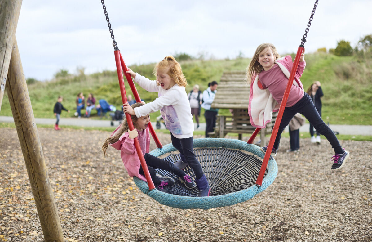 Three girls enjoying the bucket swing
