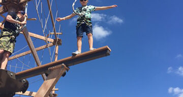 A child balancing at Sky Ropes