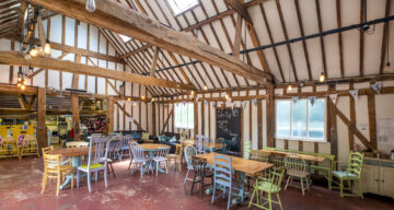 A beamed cafe with seating and tables