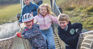 Group of kids on a play trail bridge