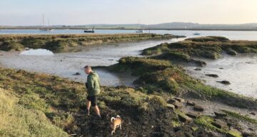 Man and dog at low tide on river Crouch