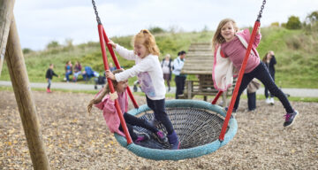 Three girls enjoying the bucket swing