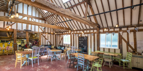 A beamed cafe with seating and tables