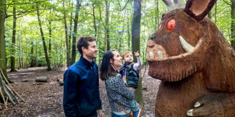A family admiring a wooden carving of The Gruffalo