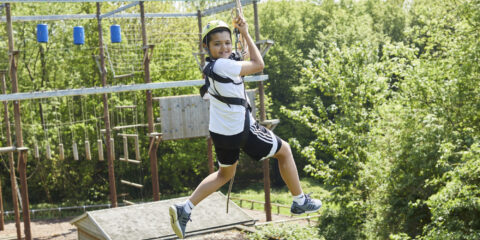 A young boy swinging on a rope