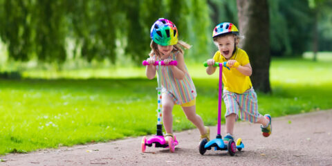 A young boy and girl on scooters