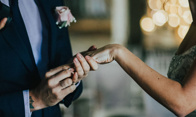 The groom placing a ring on the bride's finger