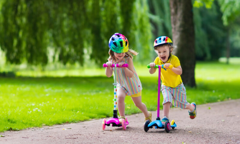 A young boy and girl on scooters